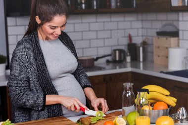 Kadın mutfakta sebze ve meyve kesiyor, sağlıklı gıda konsepti. 
