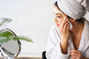 Salatalık, limon ve baldan doğal maske yapan güzel genç bir kadın.