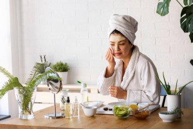 Salatalık, limon ve baldan doğal maske yapan güzel genç bir kadın.