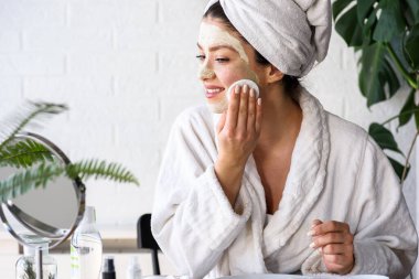 Salatalık, limon ve baldan doğal maske yapan güzel genç bir kadın.