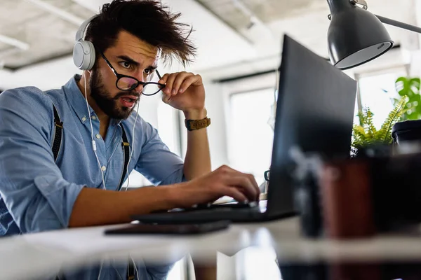 stock image young handsome man working at home in headphones