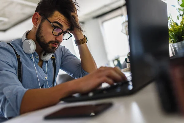 stock image young handsome man working at home using laptop