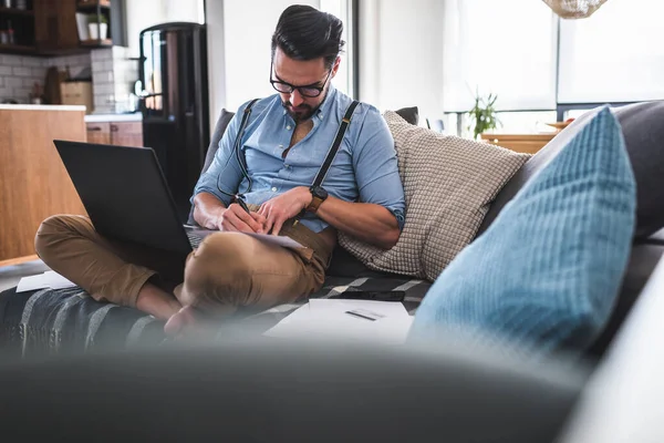 stock image young man using laptop, working at home