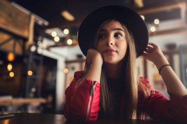 Kafede deri ceketli ve şapkalı güzel bir kadın..