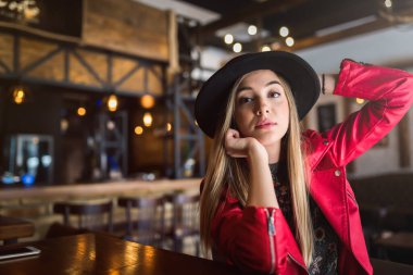 Kafede deri ceketli ve şapkalı güzel bir kadın..