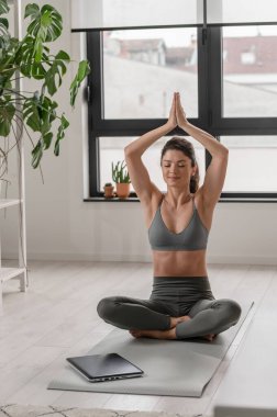 Evde esneme egzersizleri yapan çekici bir kız. Güzel bir kadın yoga ve meditasyon yapıyor.. 