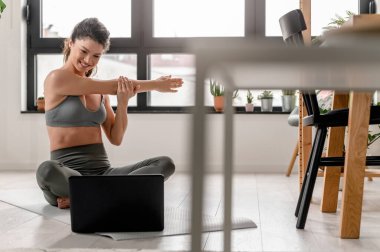 Evde esneme egzersizleri yapan çekici bir kız. Güzel bir kadın yoga ve meditasyon yapıyor.. 