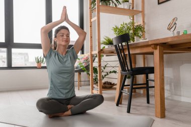 Evde esneme egzersizleri yapan çekici bir kız. Güzel bir kadın yoga ve meditasyon yapıyor.. 
