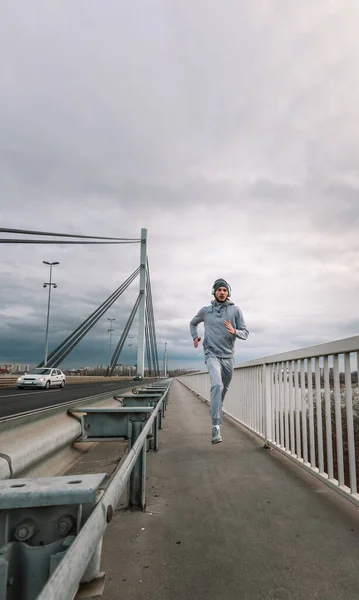 stock image man running on the bridge in the city 