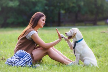 Mutlu kadın köpeğini parkta oynarken 