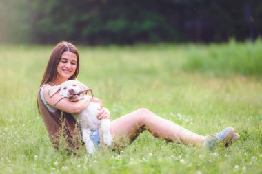 Genç bir kadın halka açık parkta şirin Labrador Retriever 'la oynuyor. Köpek en iyi arkadaş.