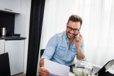 Genç adam evde çalışıyor. 