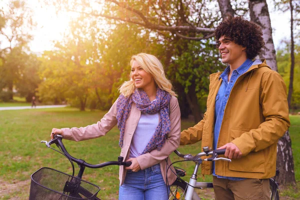年轻夫妇骑着自行车在公园里散步 — 图库照片