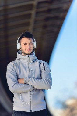Kulaklığı ve telefonu olan yakışıklı bir koşucu.