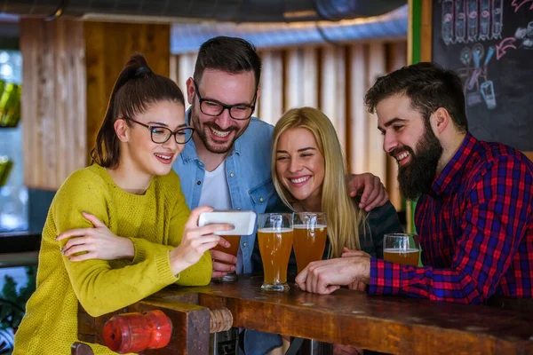 Φίλοι Στο Μπαρ Πίνοντας Μπύρα Ψάχνουν Smartphone — Φωτογραφία Αρχείου