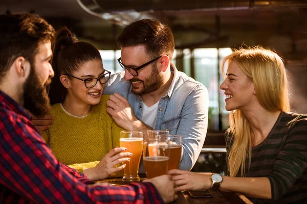 酒吧里的一群年轻朋友喝啤酒 — 图库照片