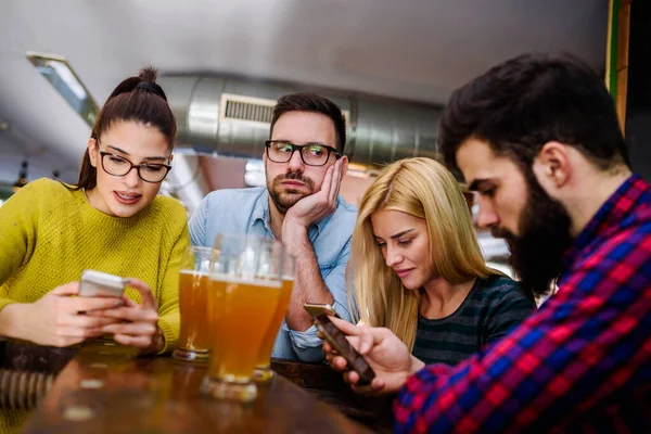 Φίλοι Στο Μπαρ Πίνοντας Μπύρα Smartphones — Φωτογραφία Αρχείου