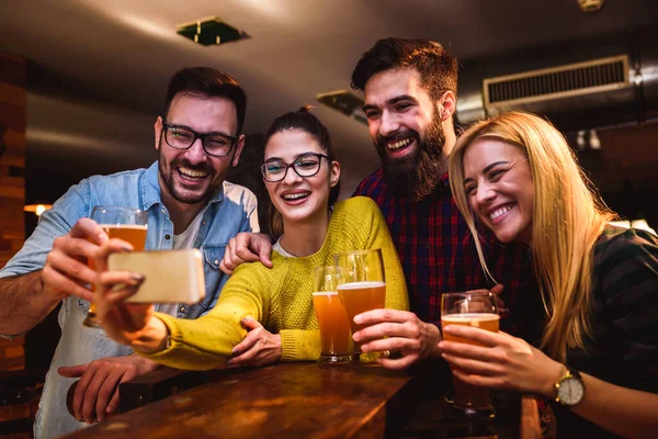 Vrienden Aan Bar Die Bier Drinken Zoek Naar Smartphone — Stockfoto
