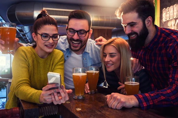 Φίλοι Στο Μπαρ Πίνοντας Μπύρα Ψάχνουν Smartphone — Φωτογραφία Αρχείου
