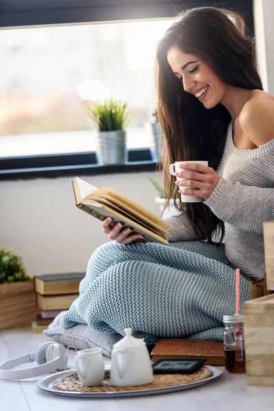 Молодая Женщина Читает Книгу Наслаждаясь Окна Современной Квартиры — стоковое фото
