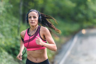 Genç bir kadın dışarıda koşuyor.