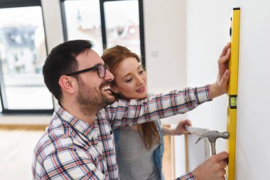Boş bir dairede duvarları ölçen bir çift. Taşındıktan ve yenilendikten sonra etkinlikler.