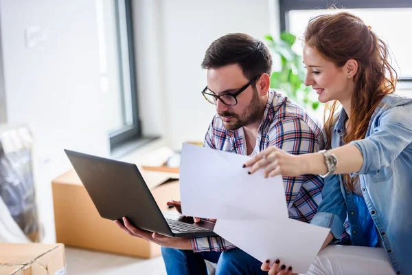 stock image happy young couple using laptop, moving to new home