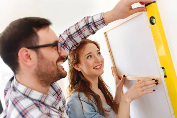 stock image Couple in empty apartment measuring walls. Activities after relocation and renovation.