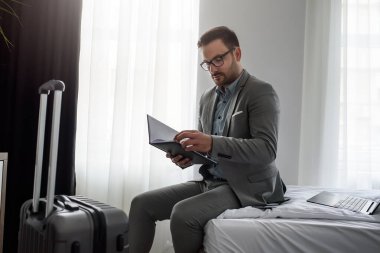 İşadamı dizüstü bilgisayar kullanıyor, otel odasında çalışıyor. İş seyahati..