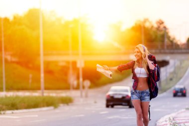 Şehirde günbatımında kot şortlu güzel sarışın kadın. 