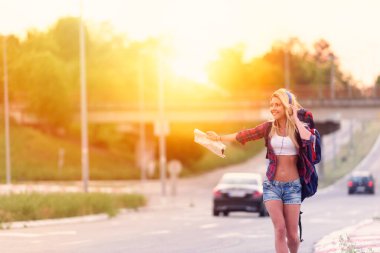 Şehirde günbatımında kot şortlu güzel sarışın kadın. 