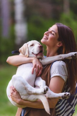 Parkta köpeği olan genç bir kadın. 