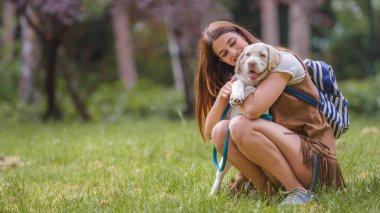 Parkta köpeği olan genç bir kadın. 