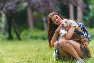 Parkta köpeği olan genç bir kadın. 