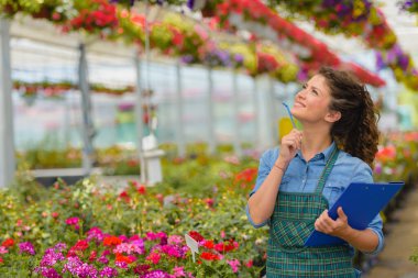 Serada çalışan genç bir kadın bahçıvan.
