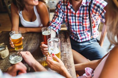 Arkadaşlar bir barda içiyor ve kadeh kaldırıyor.