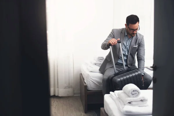 stock image young man with a suitcase in the hotel room