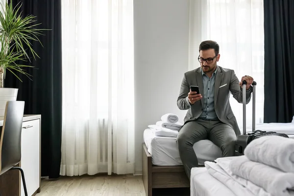 stock image young man with a suitcase in the hotel room