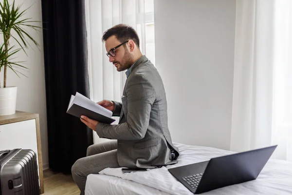 stock image Traveling for work. Elegant businessman sitting in his hotel room working