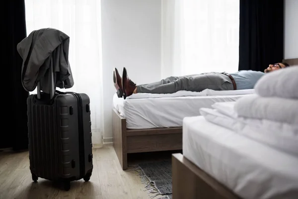 stock image man lying on the bed at hotel room