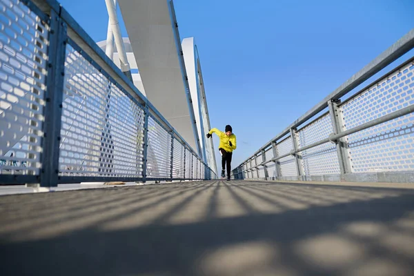 stock image young man jogging on the bridge in the city 