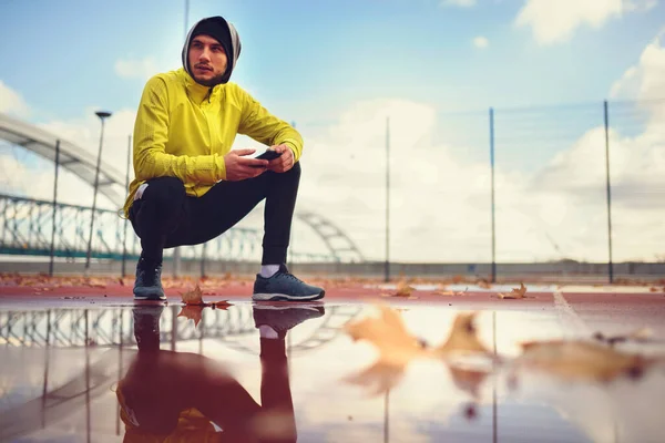 Πορτρέτο Του Νεαρού Αθλητή Στο Αντιανεμικό Χρησιμοποιώντας Smart Phone Την — Φωτογραφία Αρχείου