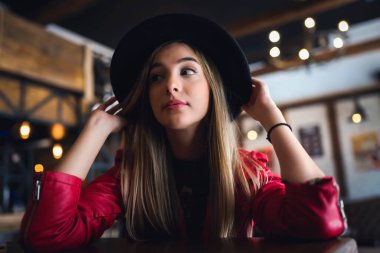 Kafede poz veren şapkalı güzel bir kadın.