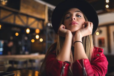Kafede poz veren şapkalı güzel bir kadın.
