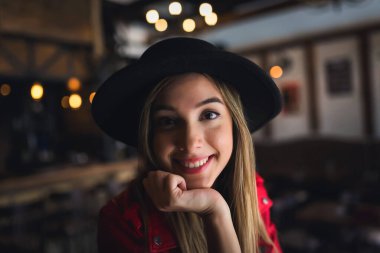 Kafede poz veren şapkalı güzel bir kadın.