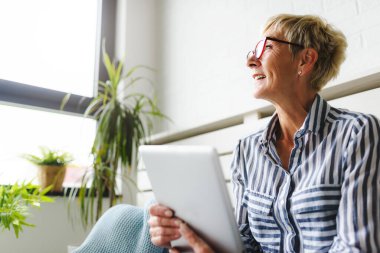 Güzel Olgun kadın evde tablet kullanma