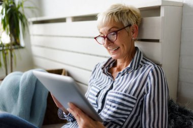 Güzel Olgun kadın evde tablet kullanma