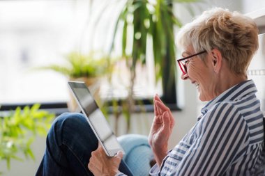Güzel Olgun kadın evde tablet kullanma