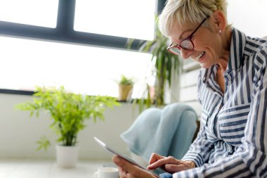 Güzel Olgun kadın evde tablet kullanma