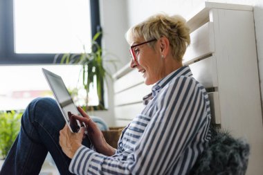 Güzel Olgun kadın evde tablet kullanma